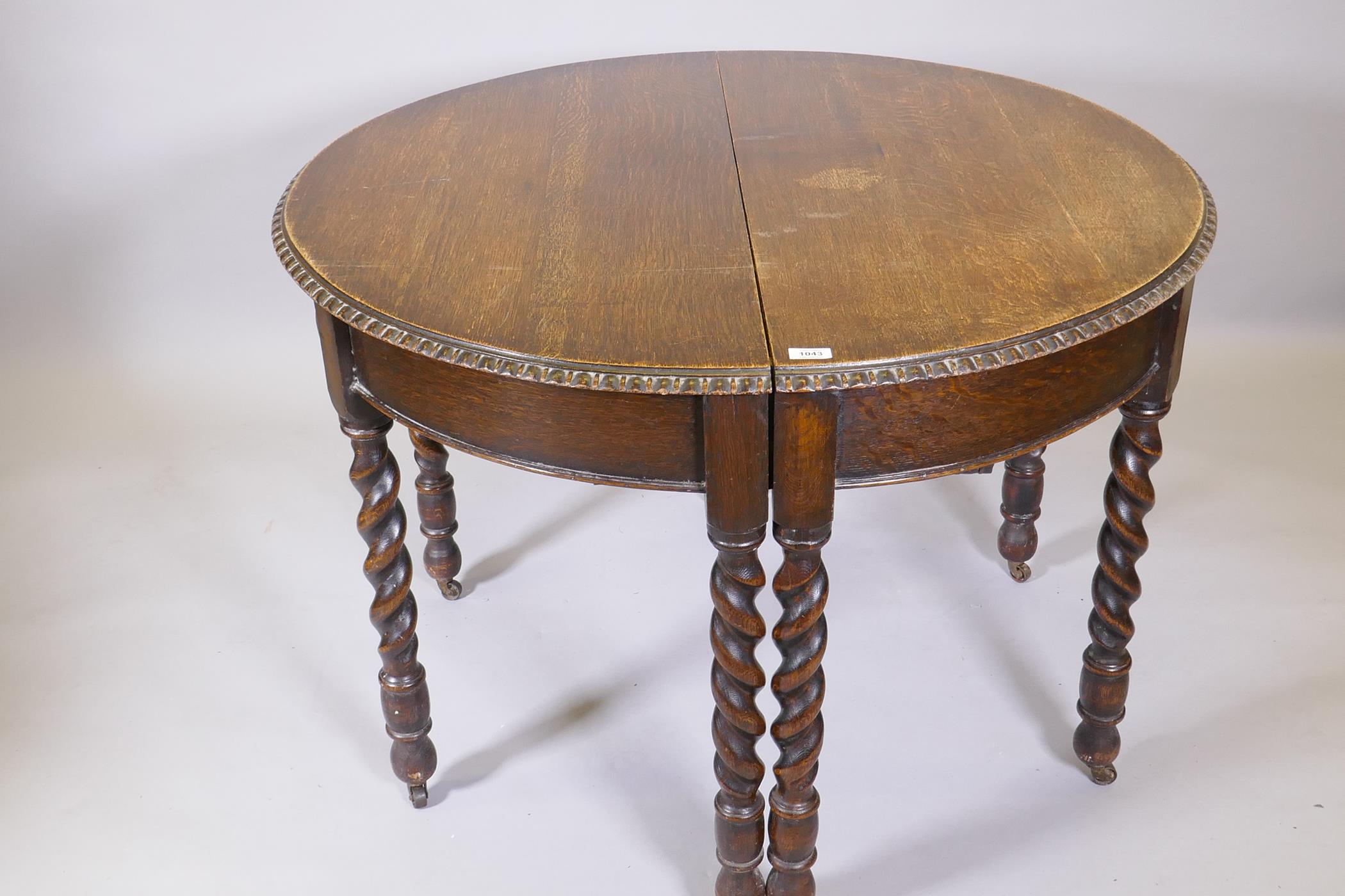 An early C20th oak wind out dining table, raised on eight handed barleytwist supports, with extra - Image 2 of 6