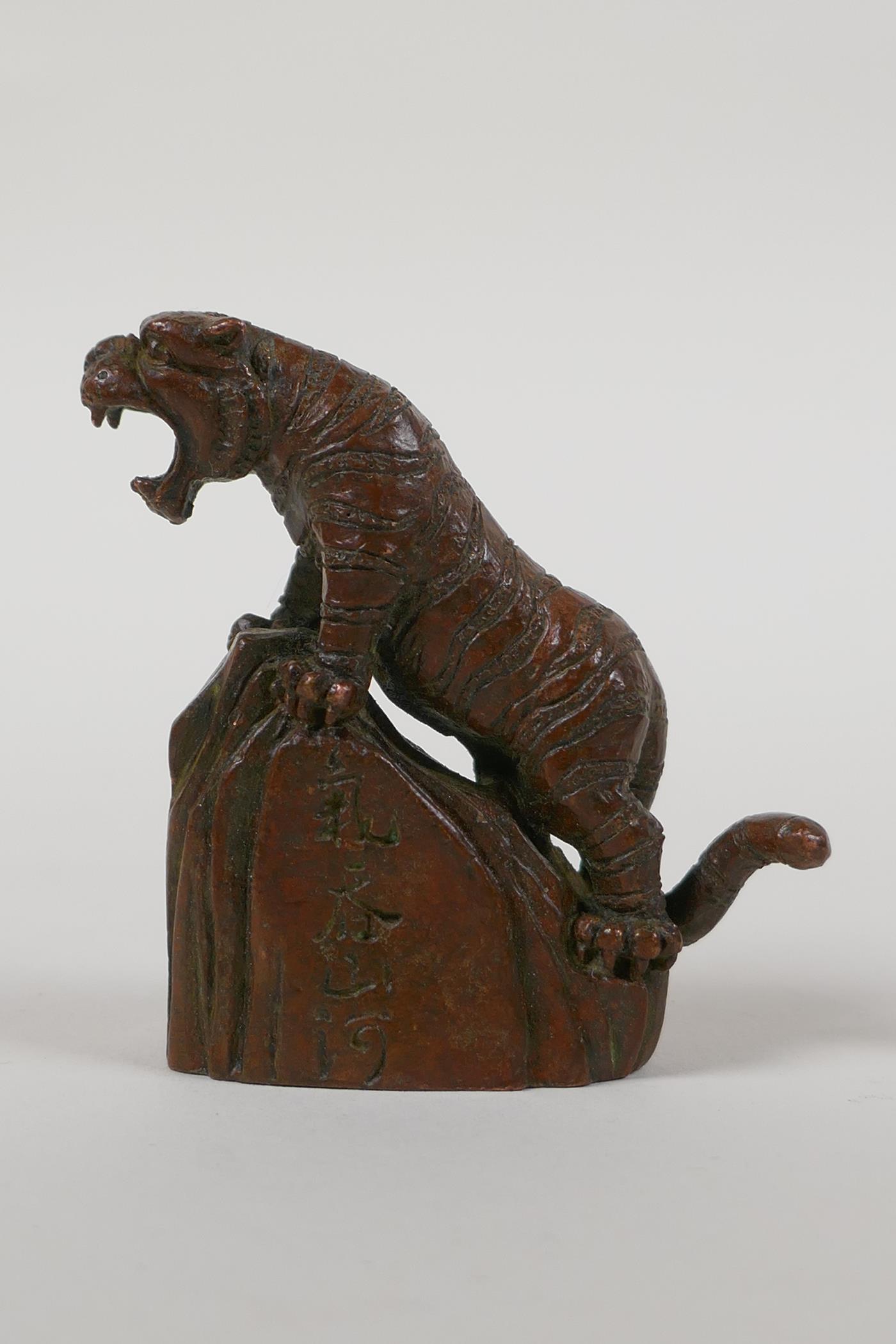 A Japanese bronze okimono of a tiger on a rock, character script to side, 2½" high - Image 2 of 4