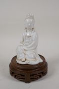 A Chinese blanc de chine porcelain Quan Yin, on a turned and pierced hardwood stand, impressed marks