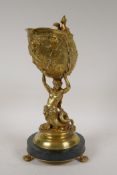 An antique bronze ormolu centre piece in the form of a mermaid holding aloft a conch shell, on a ver