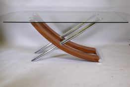 A contemporary glass top dining table, raised on a chrome and walnut finish base, 71" x 36" x 29"