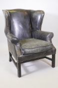 A Georgian style leather wingback armchair, 42" high