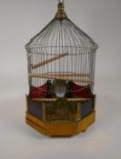 A brass bird cage with cranberry glass panels and opaline glass water feeders, AF missing foot