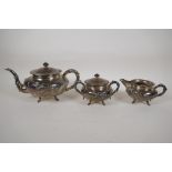 A C19th Chinese three piece silver tea set with embossed dragon decoration, bamboo shaped handles