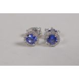 A pair of 9ct white gold stud earrings set with sapphires encircled by diamonds, approx 70 points