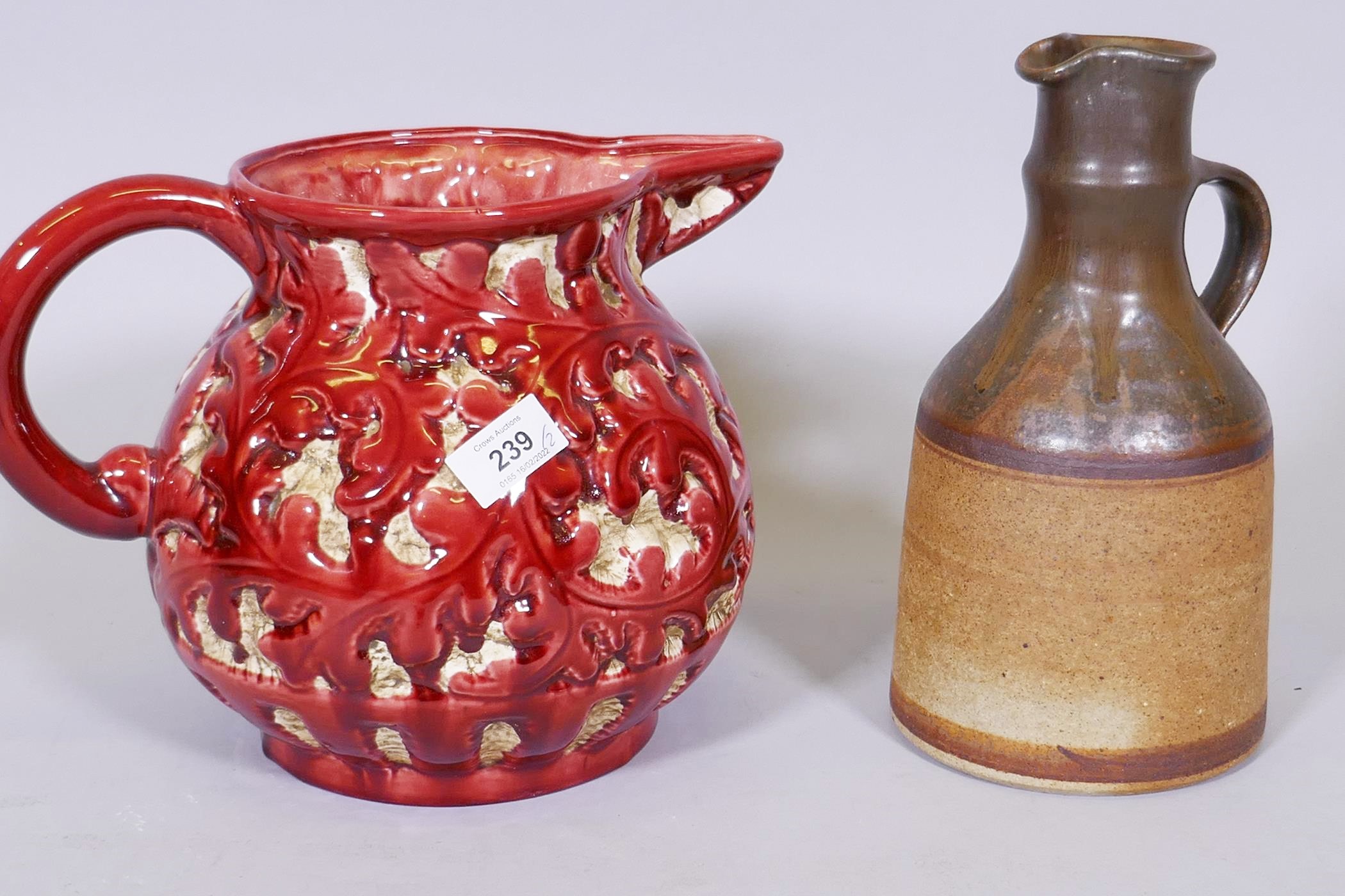 Trentham majolica jug with raised foliate design, glazed in red, 9" high, and a studio pottery