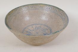 A Persian earthenware bowl with painted leaf decoration within a patterned border, 8" diameter
