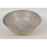 A Persian earthenware bowl with painted leaf decoration within a patterned border, 8" diameter