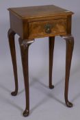 A Queen Anne style walnut single drawer lamp table, raised on cabriole supports with carved