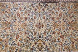 A Belgian cream ground wool Persian design carpet, decorated with an allover floral pattern and