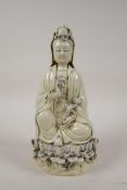 A Chinese blanc de chine porcelain Quan Yin seated on a lotus flower, impressed marks verso, 10"