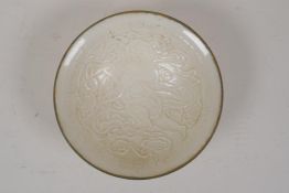 A Chinese Song style ding ware porcelain dish, decorated with a child playing an instrument, 5½"