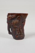 A Chinese carved horn libation cup, decorated with figures beneath trees, inscribed 4 character mark