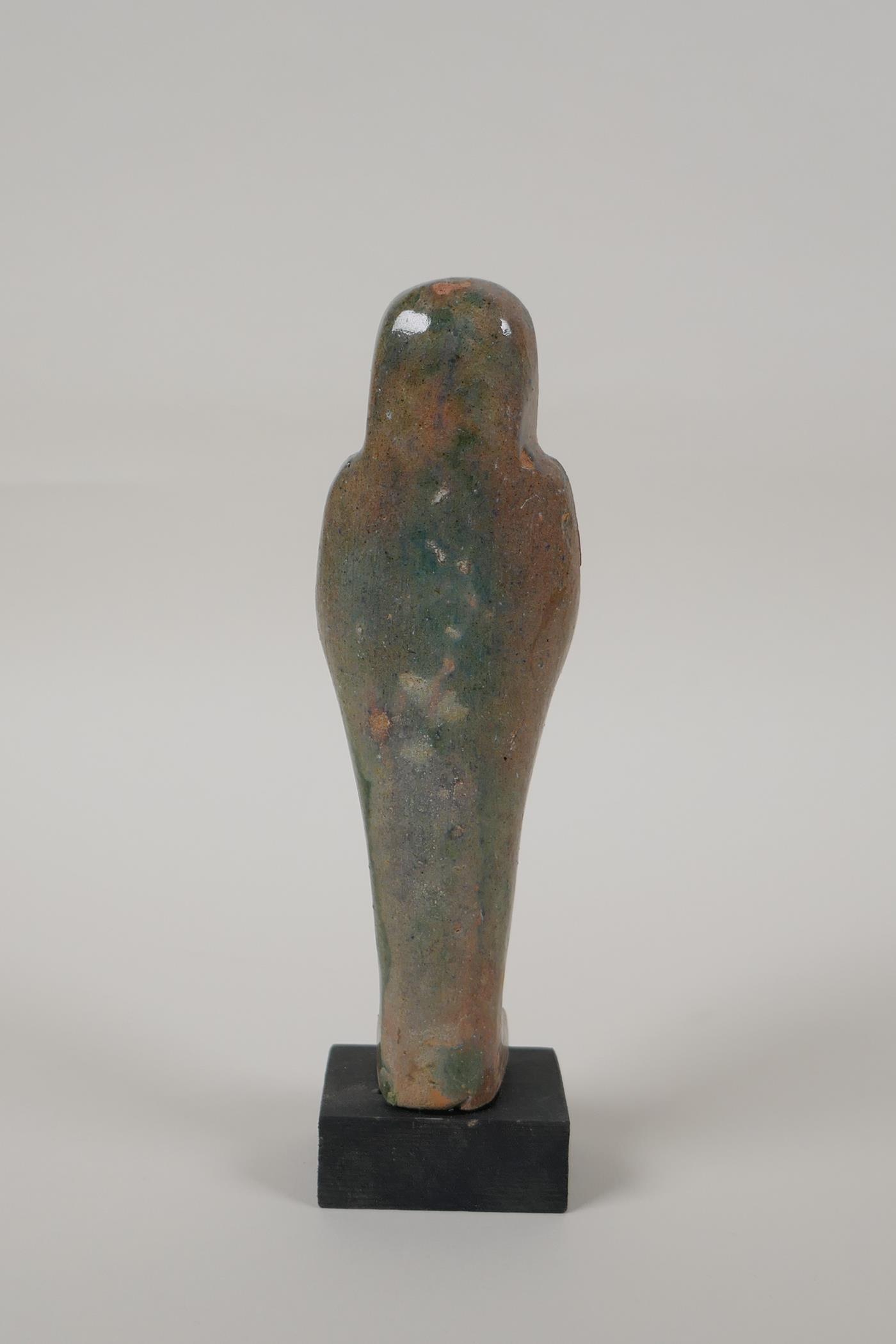 An Egyptian turquoise glazed faience shabti, mounted on a display base, 7" high - Image 3 of 4