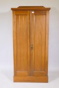 A walnut linen cupboard with two tongue and groove panelled doors, the interior fitted with
