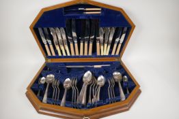 An Art Deco walnut cased canteen of silver plated cutlery, 22" wide