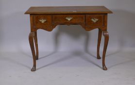 A walnut lowboy/side table, the top with quartered matched veneer and crossbanding, three drawers