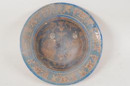 A Persian earthenware bowl decorated with figures in a garden, 9½" diameter