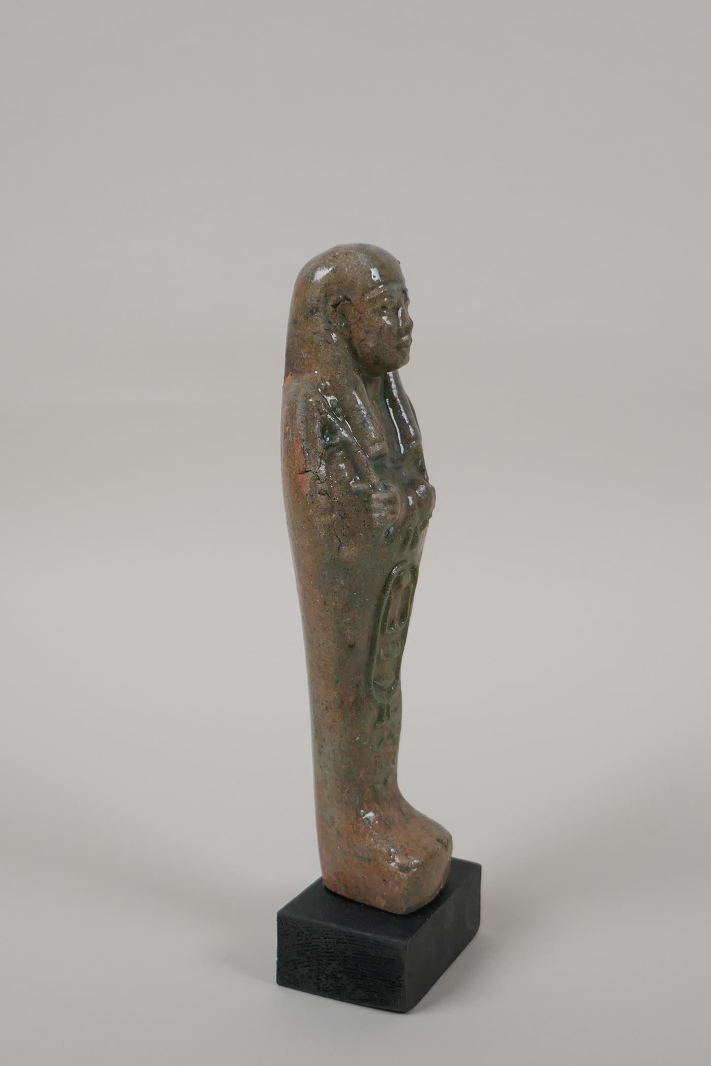 An Egyptian turquoise glazed faience shabti, mounted on a display base, 7" high - Image 2 of 4
