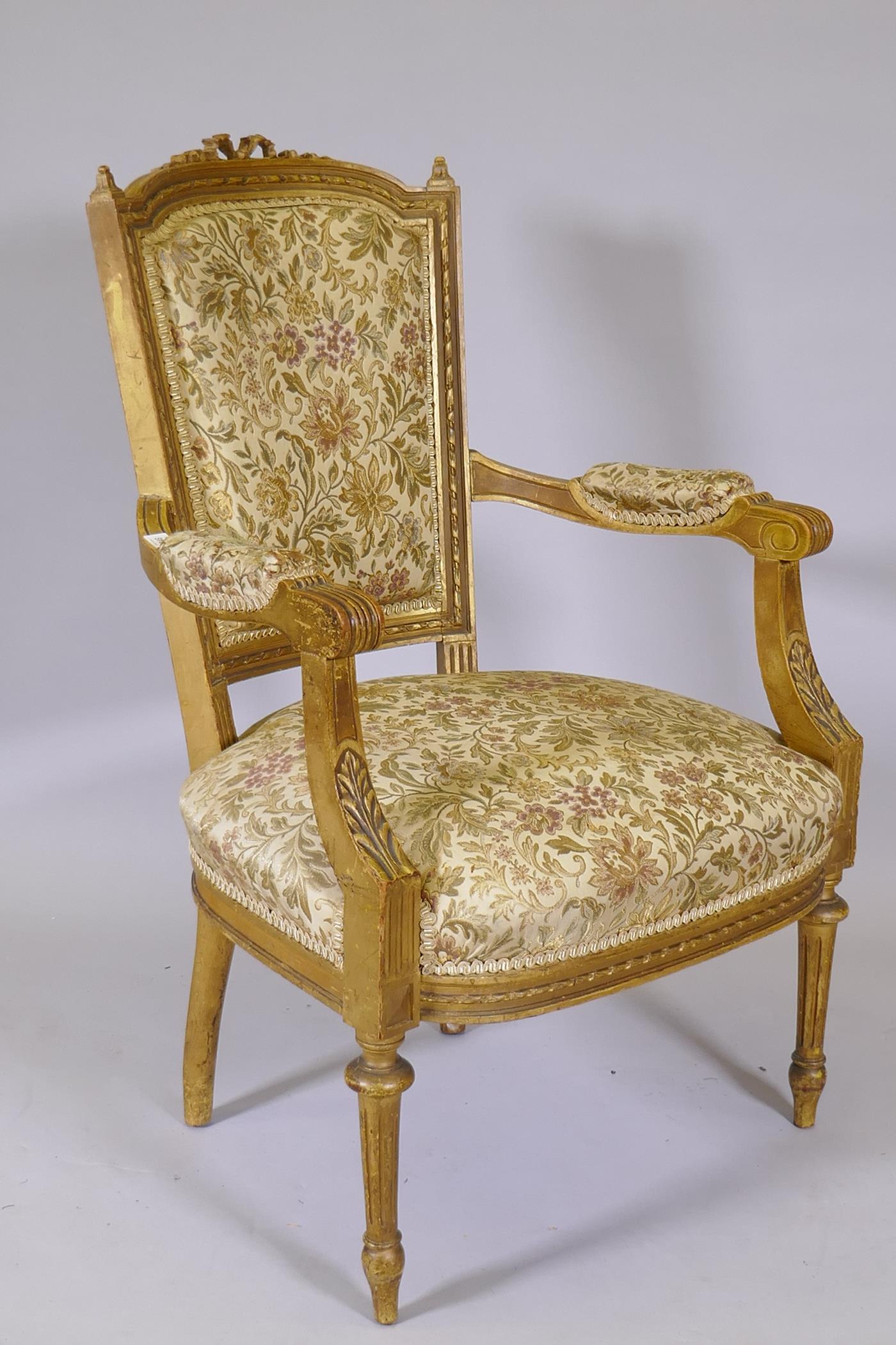 An antique French giltwood open armchair, the shaped back with carved and pierced detail, raised