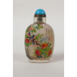 A Chinese reverse decorated glass snuff bottle depicting birds amongst branches bearing fruit and