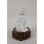 A Chinese blanc de chine porcelain Quan Yin, on a turned and pierced hardwood stand, impressed marks