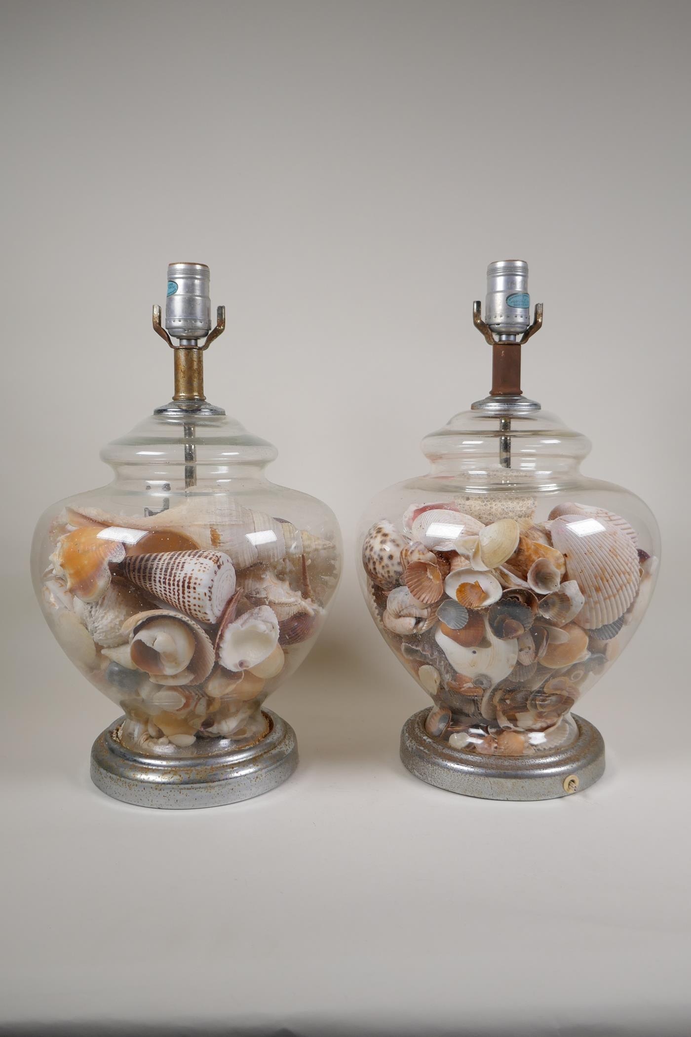 A pair of glass table lamps filled with shells, with chromed metal mounts, one AF, 15½"