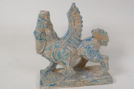 A Persian terracotta figure of Lamassu, the human headed winged bull, traces of blue glaze, 9½" high