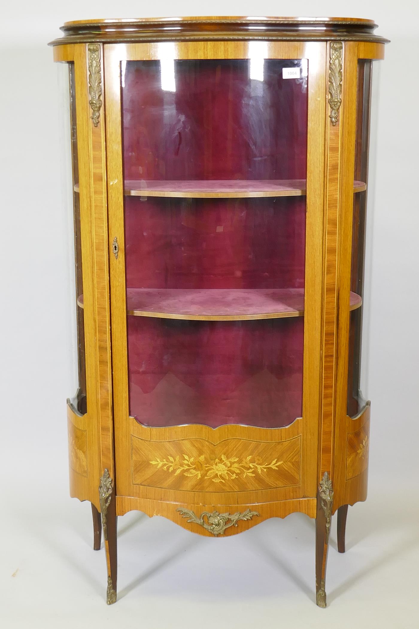 A French mahogany vitrine with tulipwood banded inlay, brass mounts and serpentine front, raised