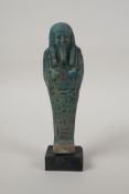An Egyptian turquoise glazed faience shabti, mounted on a display base, 7" high