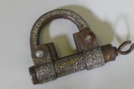 A Middle Eastern cast iron padlock with raised decoration in white and yellow metals and Islamic