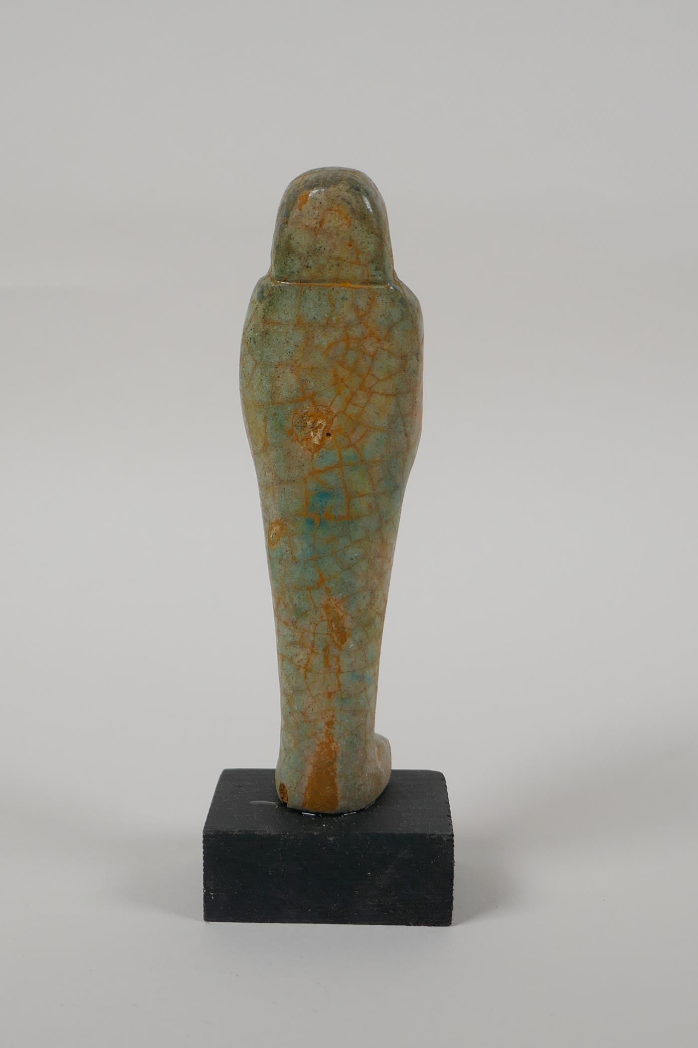 An Egyptian turquoise glazed faience shabti, mounted on a display base, 6" high - Image 4 of 6