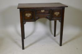 A Georgian oak lowboy, with three drawers, pierced fret brass handles, the kneehole with carved