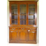 A large C19th mahogany cabinet bookcase, the upper section with three glazed doors over shelves, the