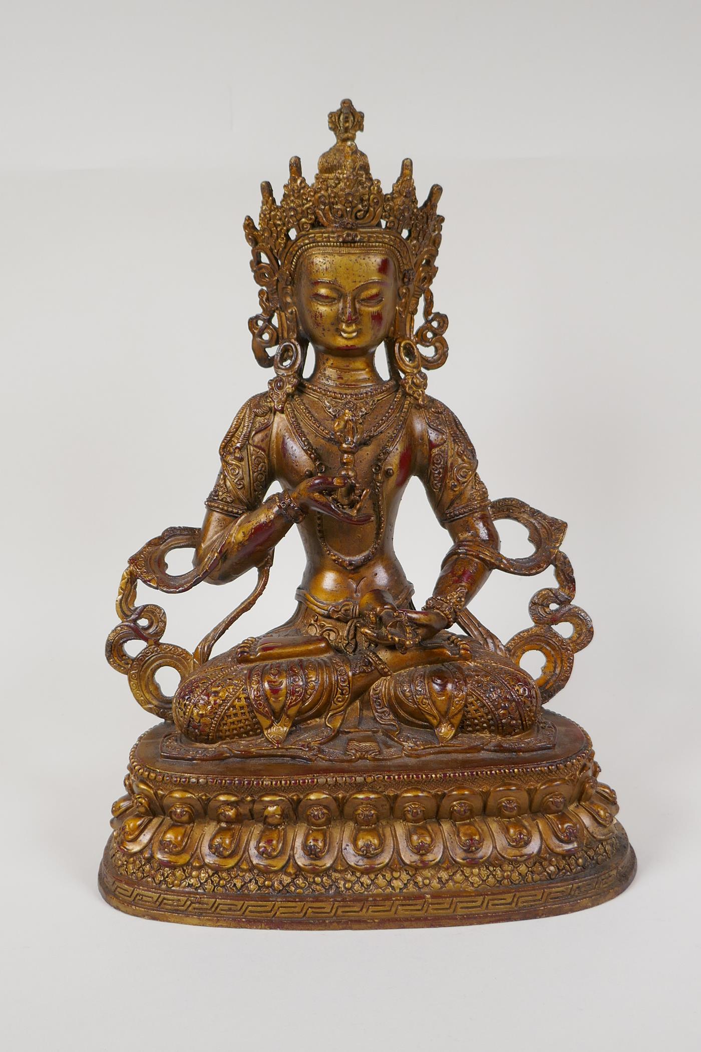 A Sino Tibetan gilt bronze of Buddha carrying two vajra, 12" high