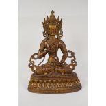 A Sino Tibetan gilt bronze of Buddha carrying two vajra, 12" high