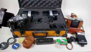 A Canon AL-1QF SLR 35mm camera, a Kodak 66 model 2 camera, and a flight cased pair of Portaflash 336