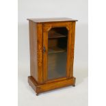 A Victorian inlaid walnut display cabinet with canted corners and single glazed door, raise on a