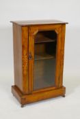 A Victorian inlaid walnut display cabinet with canted corners and single glazed door, raise on a