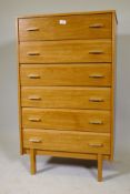 A mid century blonde mahogany veneered chest of six long drawers, raised on block supports, 26" x