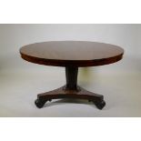 A C19th mahogany tilt top breakfast table, raised on a tapering column and platform base with scroll