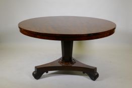 A C19th mahogany tilt top breakfast table, raised on a tapering column and platform base with scroll