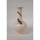 A Chinese cream glazed porcelain bottle vase with applied and gilt dragon decoration to the neck,
