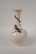 A Chinese cream glazed porcelain bottle vase with applied and gilt dragon decoration to the neck,