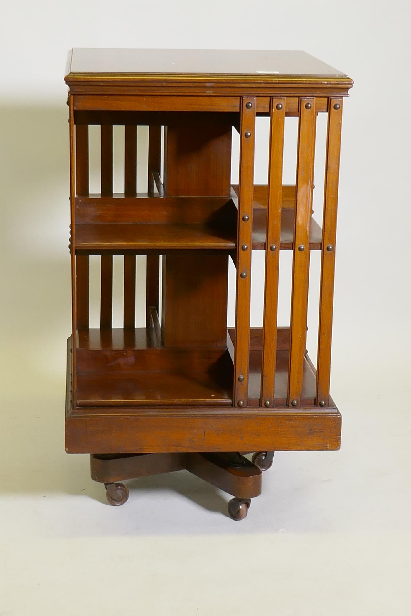 A Victorian walnut revolving bookcase, raised on a cast iron base, 20" x 20" x 34"