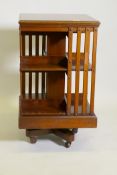 A Victorian walnut revolving bookcase, raised on a cast iron base, 20" x 20" x 34"