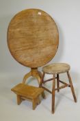 A circular pedestal breakfast table, 27" high, 29" diameter, and two rustic stools