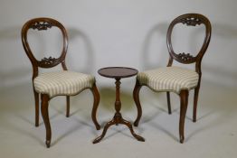 A pair of Victorian mahogany balloon back chairs and a mahogany wine table on tripod supports