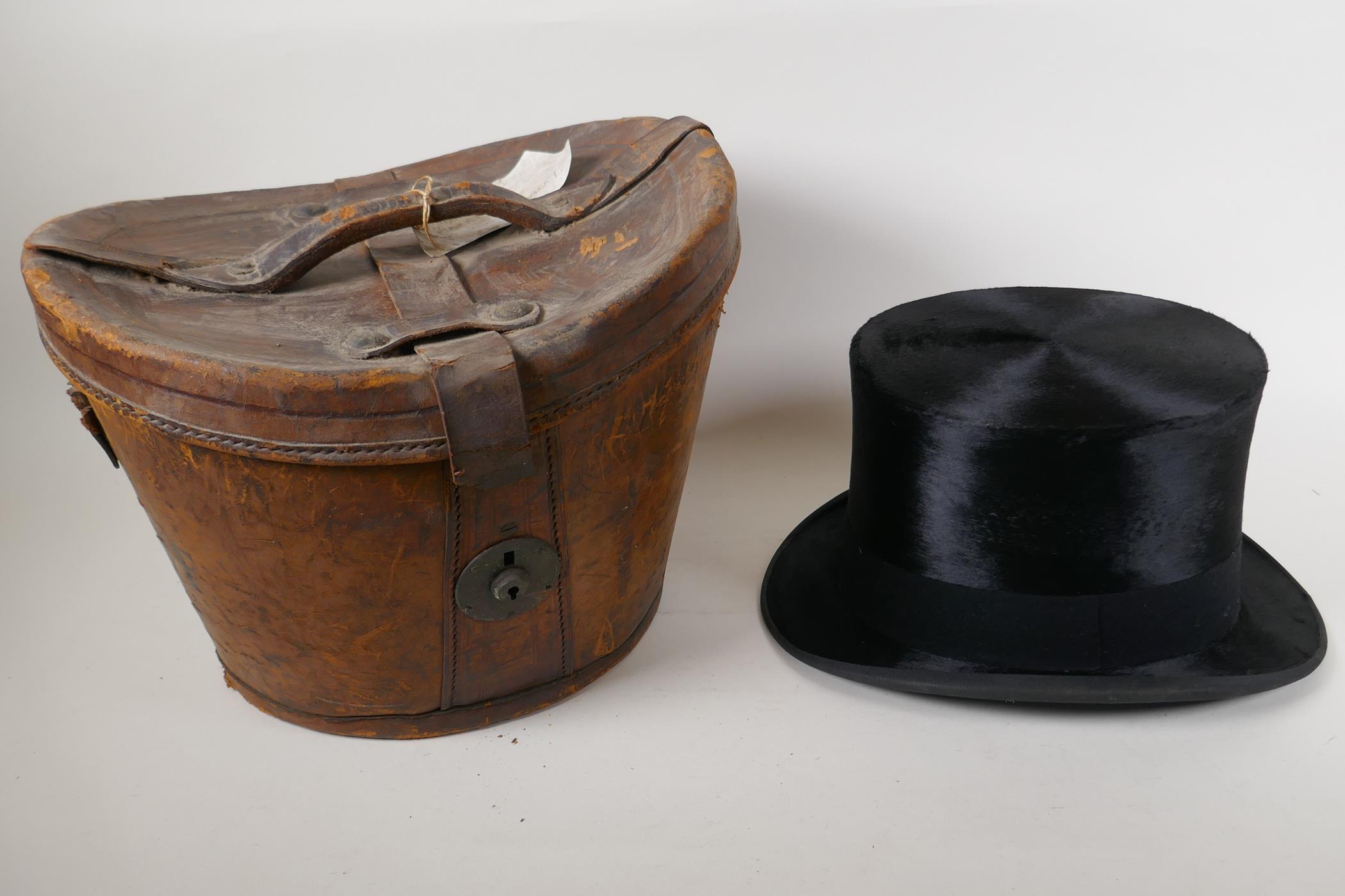 A silk top hat by Henry Heath Ltd in a leather fitted hat box