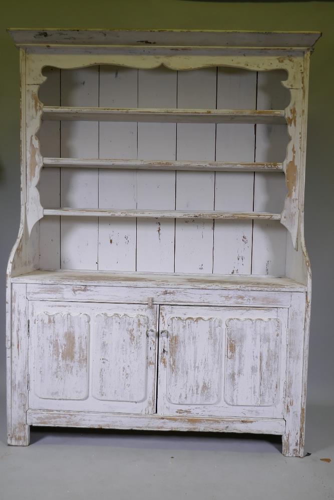 A C19th Irish painted pine dresser with closed rack over two cupboards, with decorative panelled